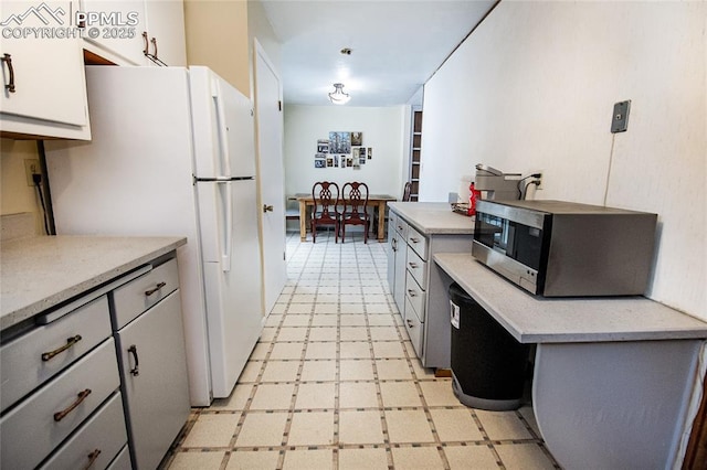 517 W Ramona Ave, Colorado Springs, CO 80905 - kitchen with gray cabinets, white cabinets, and white fridge