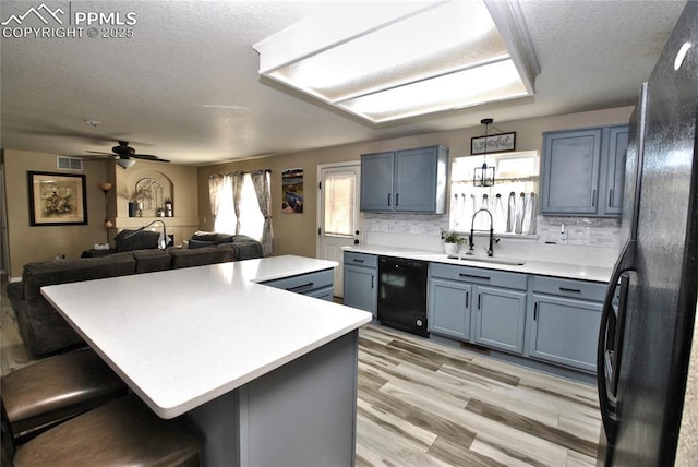 kitchen with a center island, sink, a kitchen breakfast bar, and black appliances