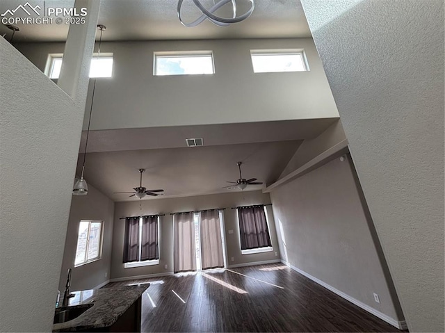 interior space featuring dark hardwood / wood-style flooring, sink, ceiling fan, and a high ceiling