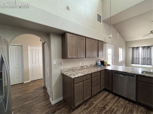 kitchen with light stone counters, hanging light fixtures, dark wood-type flooring, and stainless steel appliances