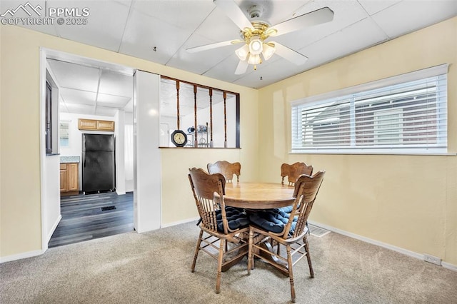 carpeted dining room featuring ceiling fan