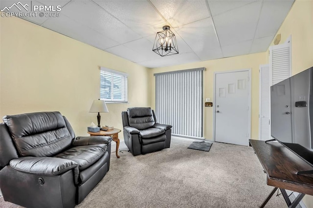 living room featuring an inviting chandelier and carpet