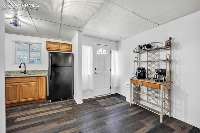 foyer entrance with dark hardwood / wood-style flooring, sink, and a drop ceiling