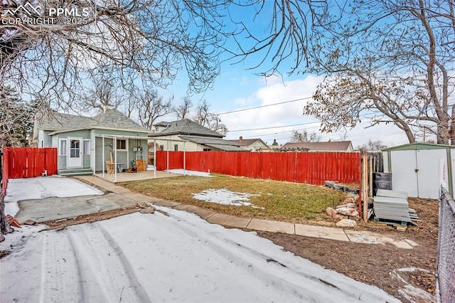 yard covered in snow with a shed