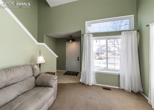 carpeted living room featuring a high ceiling