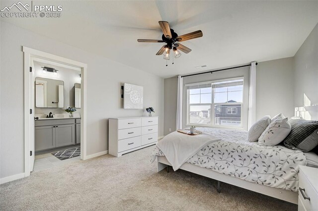 bedroom featuring ceiling fan, connected bathroom, and light carpet