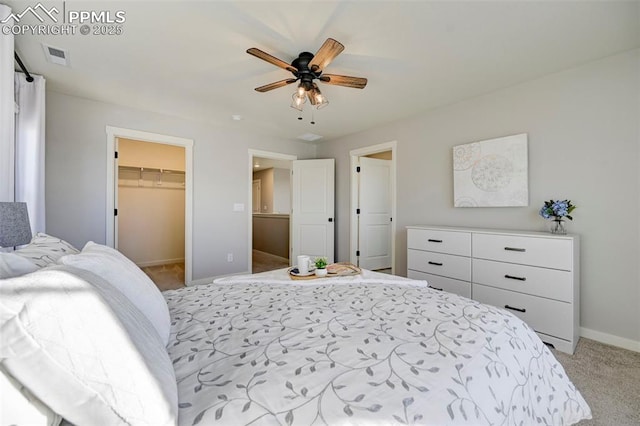 carpeted bedroom with ceiling fan, a walk in closet, and a closet