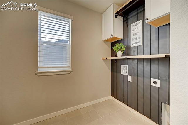 washroom featuring cabinets, light tile patterned flooring, and electric dryer hookup