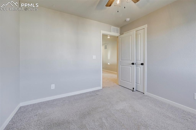 spare room with ceiling fan and light colored carpet