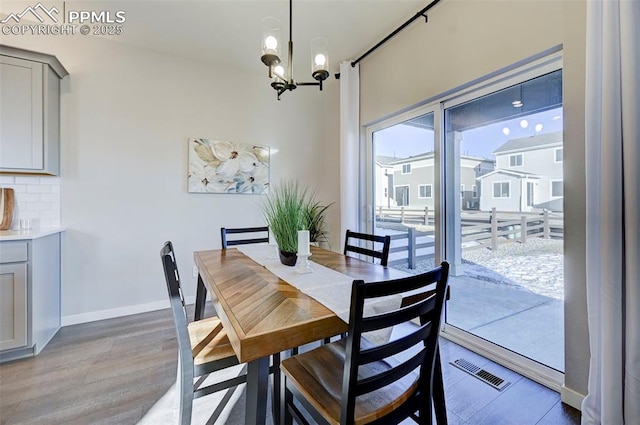 dining room with light hardwood / wood-style floors and a notable chandelier