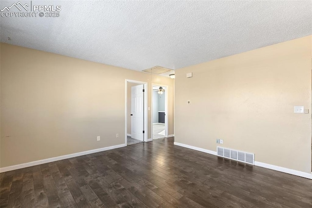 spare room featuring dark wood-type flooring and a textured ceiling