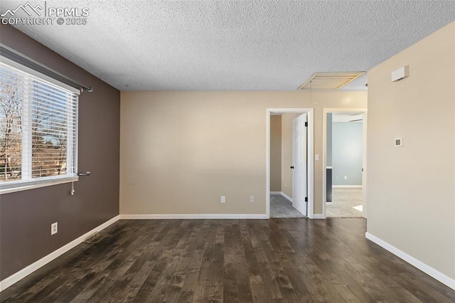 empty room featuring dark hardwood / wood-style floors and a textured ceiling