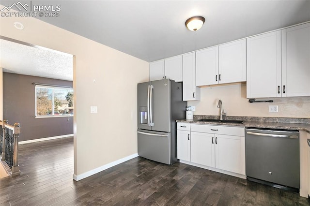 kitchen featuring sink, white cabinets, stainless steel appliances, dark wood-type flooring, and a textured ceiling