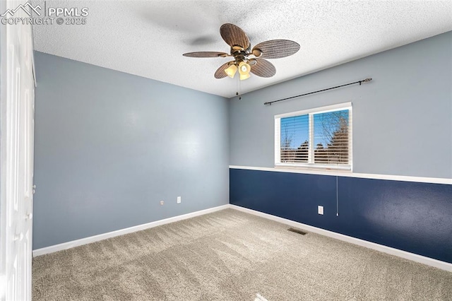 empty room with ceiling fan, carpet flooring, and a textured ceiling