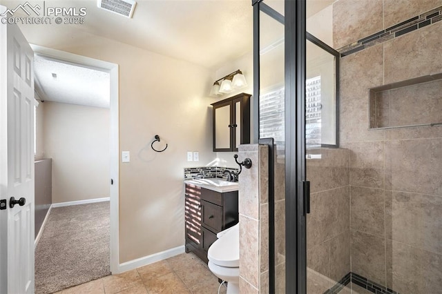 bathroom with tile patterned flooring, vanity, toilet, and walk in shower