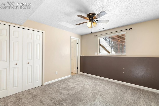 unfurnished bedroom with ceiling fan, light colored carpet, a textured ceiling, and a closet