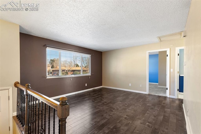 empty room featuring dark hardwood / wood-style flooring and a textured ceiling