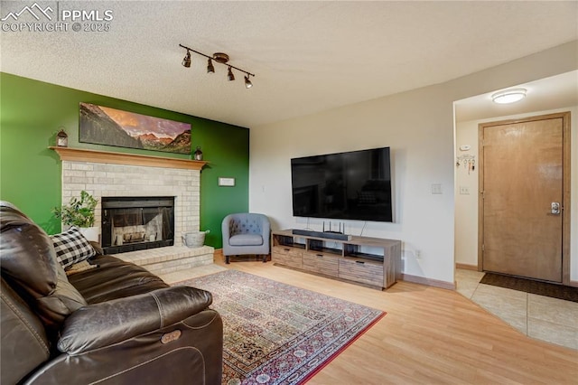 living room with hardwood / wood-style floors, a textured ceiling, and a fireplace