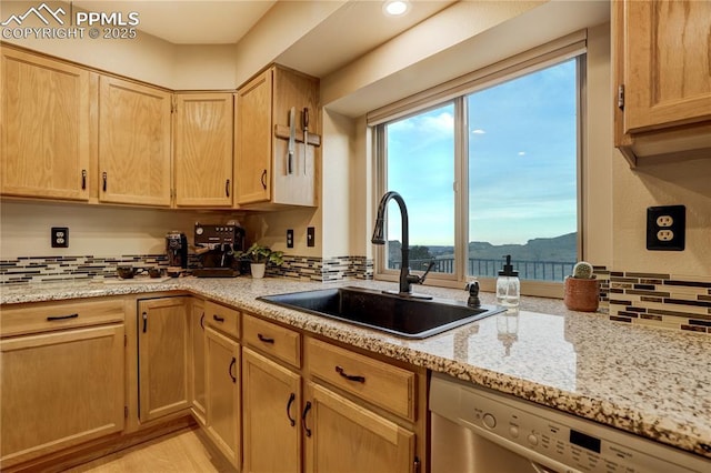 kitchen with sink, light stone counters, a water and mountain view, light brown cabinets, and stainless steel dishwasher