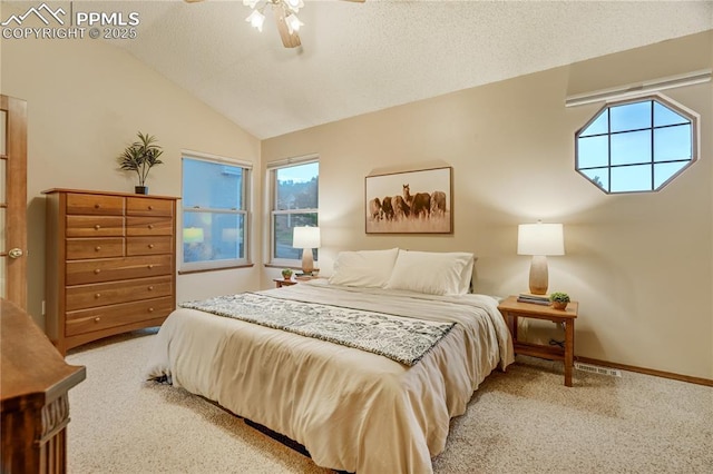 carpeted bedroom with vaulted ceiling, ceiling fan, and a textured ceiling