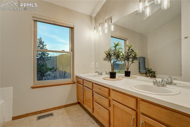 bathroom featuring vanity, lofted ceiling, and tile patterned floors