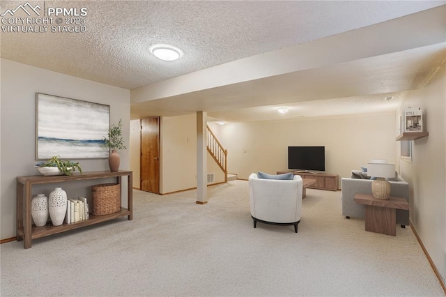 carpeted living room featuring a textured ceiling