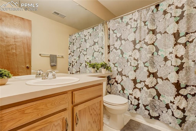 bathroom featuring tile patterned flooring, vanity, and toilet