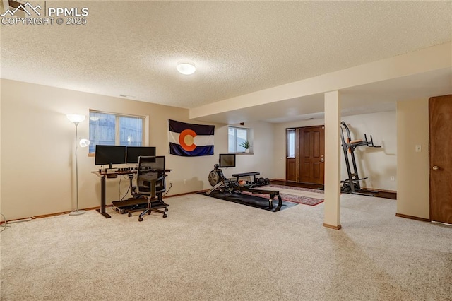 exercise area with carpet flooring and a textured ceiling