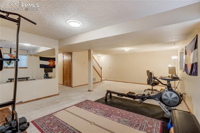 workout room featuring carpet floors and a textured ceiling