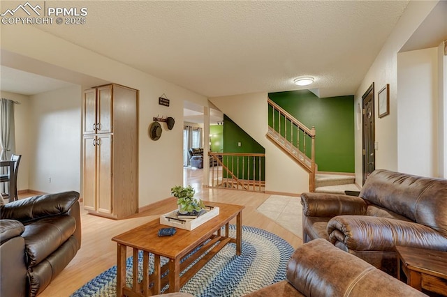 living room featuring light hardwood / wood-style flooring and a textured ceiling