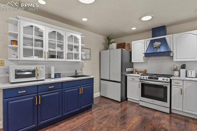 kitchen with premium range hood, blue cabinets, sink, stainless steel appliances, and white cabinets