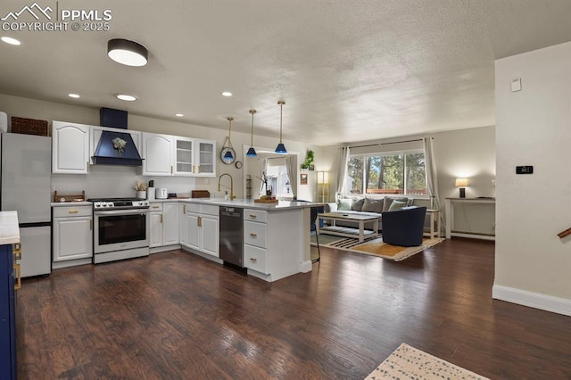 kitchen featuring pendant lighting, wall chimney range hood, appliances with stainless steel finishes, white cabinetry, and kitchen peninsula