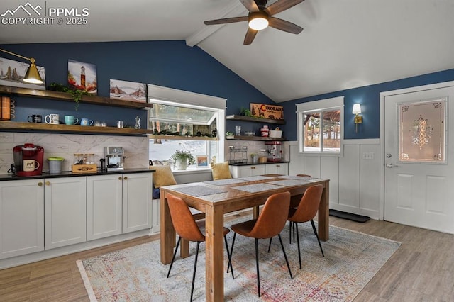 dining area with vaulted ceiling with beams, ceiling fan, and light hardwood / wood-style flooring