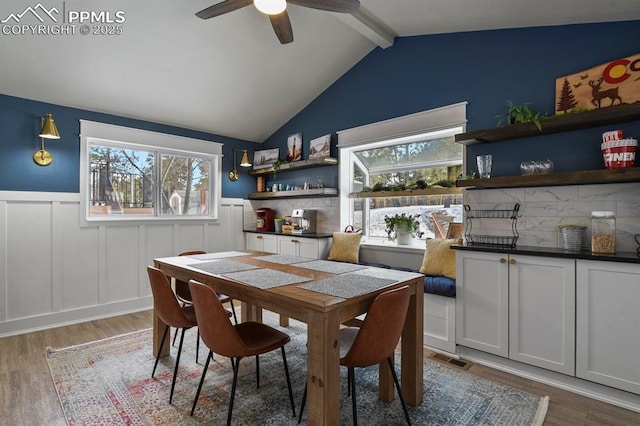 dining area with lofted ceiling with beams, ceiling fan, and hardwood / wood-style floors