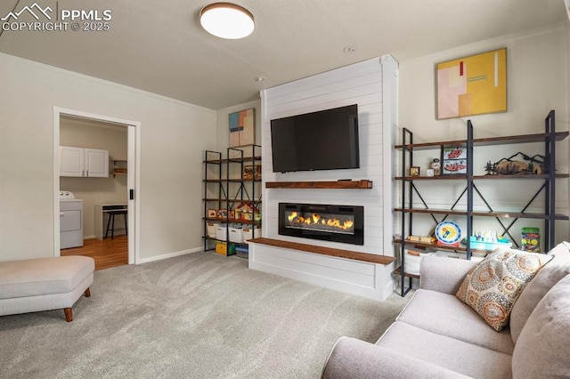 carpeted living room with washer / clothes dryer and a large fireplace