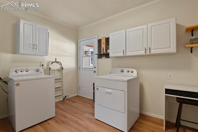 laundry room featuring separate washer and dryer, light hardwood / wood-style floors, and cabinets