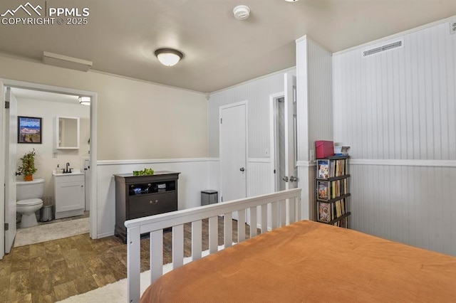 bedroom with sink, connected bathroom, and dark wood-type flooring