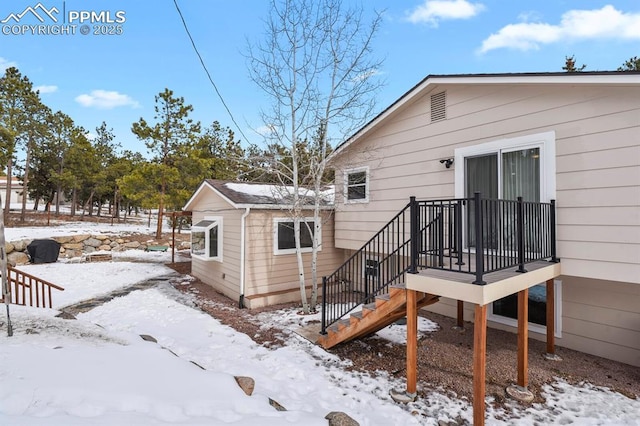 snow covered property with an outbuilding