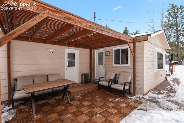 snow covered patio featuring a pergola