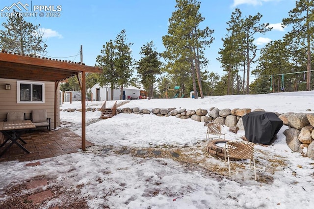 yard covered in snow with an outdoor fire pit and a pergola