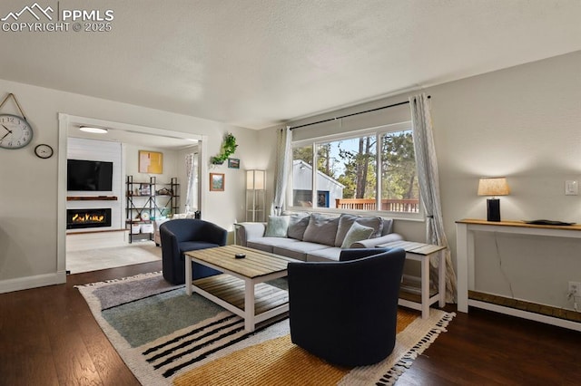 living room featuring dark wood-type flooring and a textured ceiling