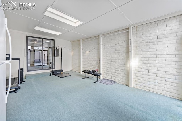 workout room with carpet and brick wall