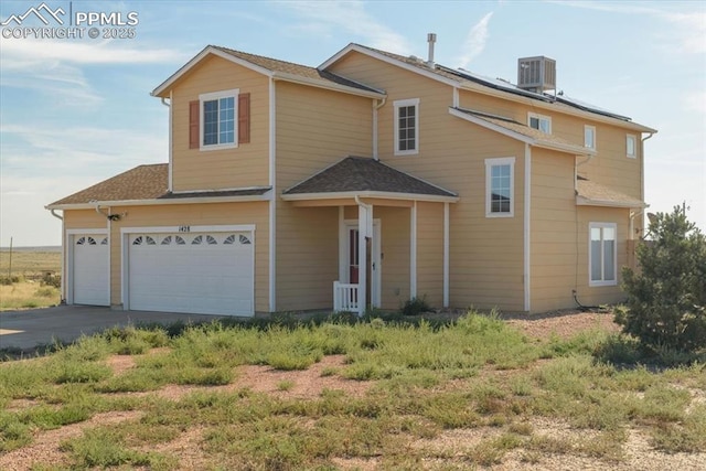 view of front property featuring a garage and central AC unit