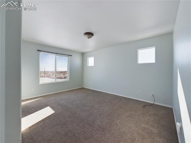 spare room with dark colored carpet