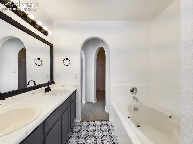 bathroom featuring tile patterned flooring, vanity, and a tub