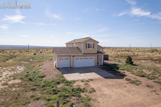 view of front of home with a garage and a rural view