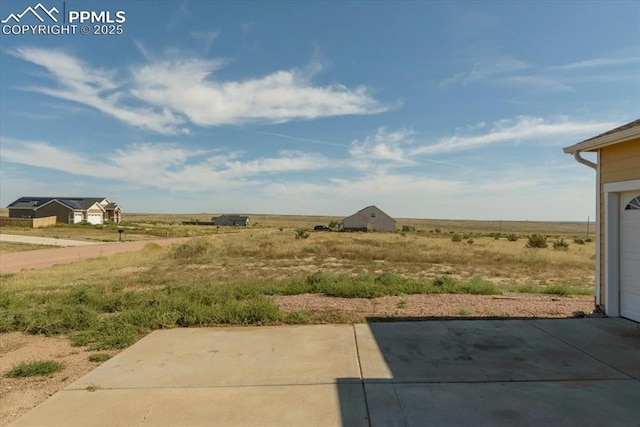 view of yard featuring a rural view and a patio area