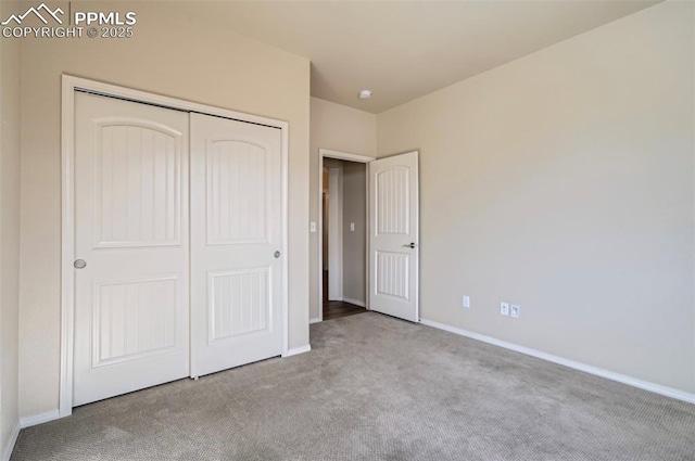 unfurnished bedroom featuring baseboards, a closet, and carpet floors