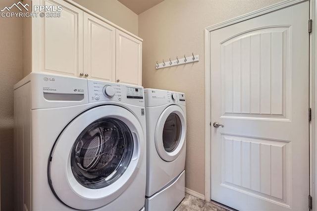 laundry room with washing machine and clothes dryer and cabinet space