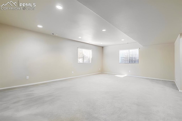 unfurnished room with light colored carpet, recessed lighting, visible vents, and baseboards